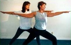 Nancy Rakela, LAc, OMD demonstrating a yoga posture with friend